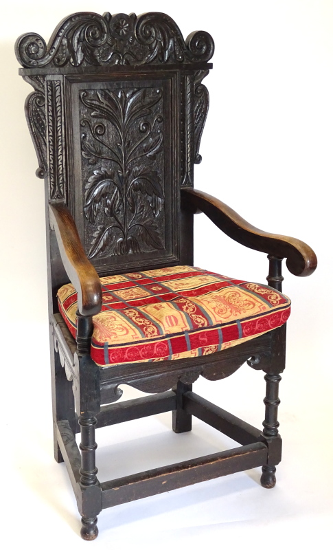 A 19thC and earlier oak Wainscot chair, the panelled back carved with leaves, flowers, scrolls, etc,