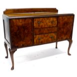 An early 20thC walnut sideboard, with a raised back, top with a concave moulded edge, above two