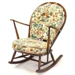 An Ercol type spindleback rocking chair, with a padded back and seat. The upholstery in this lot