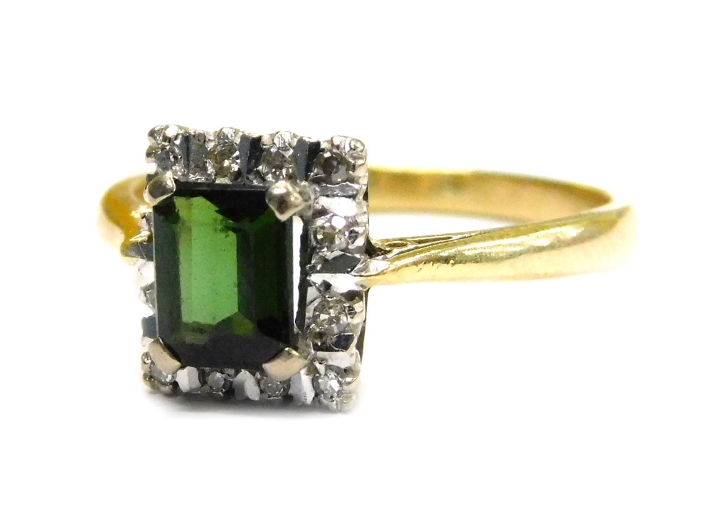 An 18ct gold stone set dress ring, with square dark green stone in four claw setting, surrounded