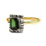 An 18ct gold stone set dress ring, with square dark green stone in four claw setting, surrounded