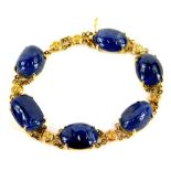 A 9ct gold polished sapphire bracelet, of graduated design set with various oblong uncut stones,