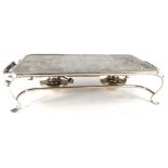 A silver plated rectangular warming plate, with side handles and two burners on shaped legs.