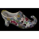 A French faience model of a shoe, decorated in famille rose enamels, makers stamp D and a flowerhead