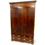 A mahogany wardrobe, with a moulded cornice oval and circular pattera inlaid frieze, above two