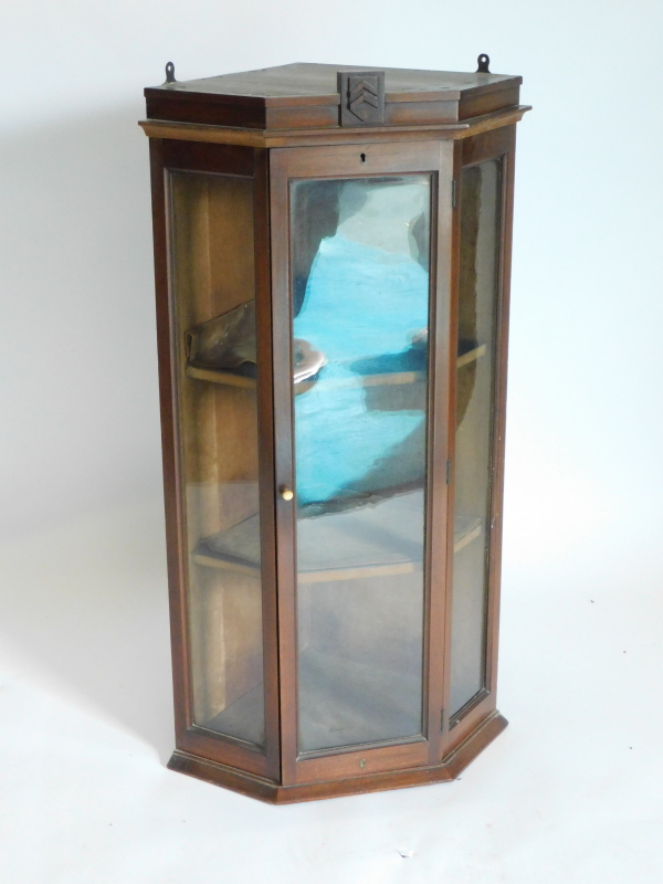 A mahogany hanging corner cabinet, with a single glazed door, flanked by glazed sides enclosing a