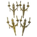 A set of four Louis XVI style two branch gilt metal wall lights, each cast with an urn, drapes and