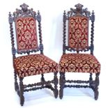 A pair of late Victorian carved oak side chairs, each decorated with a balls head type crest, on