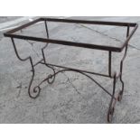 A wrought iron table base, on shaped supports, 73cm high, the top 50cm x 99cm.