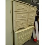 A cream bedroom chest of three drawers, and a pair of bed side cabinets, each with ceramic handles