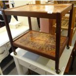 A teak 1970s trolley, inset with coloured tiles.