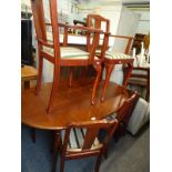 A mahogany extending oval dining table, and four chairs, two with arms. The upholstery in this lot