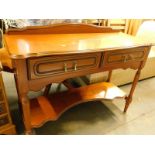 A 20thC side table, with two frieze drawers, raised above turned legs joined by a shaped undertier.