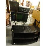 A glass three tier TV stand, a glass topped table with metal base, a Kenwood 900w microwave, metal
