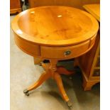 A yew wood drum table, on circular form with a wide crossbanding and real and dummy drawers, on