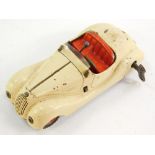 A Schuco Examico 4001 tin plate clockwork motor car, cream with red interior, with key and box.