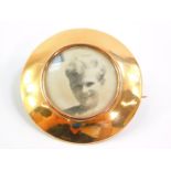 A circular photograph locket brooch, yellow metal stamped 15ct, 4cm diameter, 10.0g all in.