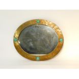 A Liberty & Co oval brass mirror, framed with four Ruskin ceramic roundels, rebacked, 53cm high,