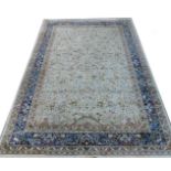 A Tabriz design blue ground rug, decorated with birds, beasts and trees, within floral borders,