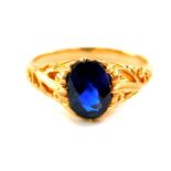 A blue stone ring, possible a spinel, oval cut, set in yellow metal, size K.