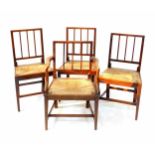 A set of four George III oak and rush seated dining chairs, comprising one carver and three single