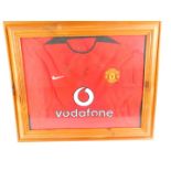 A Manchester Utd Vodafone red football shirt, bearing signatures for David Beckham, Rio Ferdinand,