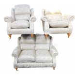 A Parker Knoll three piece suite, covered in foliate fawn fabric, comprising two seater sofa,