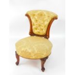 A Victorian mahogany nursing chair, with a button shield shape back, upholstered in gold floral