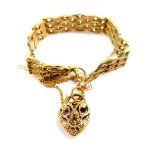 A 9ct gold stylised gate bracelet, on a pierced heart shaped padlock clasp, with safety chain as