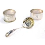 An Edward VII silver sugar sifting spoon, Birmingham 1909, together with two silver napkin rings,