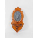 A Victorian mahogany shield shaped wall mirror, inset oval glass, above a galleried shelf, 36cm