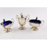 An Edward VII Art Nouveau silver composite three piece condiment set, of triple handled footed form,