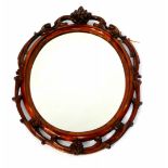A Victorian walnut oval wall mirror, with carved floral and scrolling foliate decoration, 91cm high,