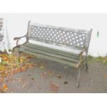 A garden bench, with cast iron supports and slatted seat and lattice back.