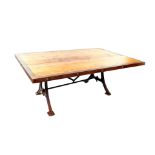 A pine and cast iron kitchen dining table, having a six plank top, with iron surround, raised on a