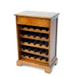 An oak wine rack, of chest form, with a single frieze drawer, above five bottle trays, raised on