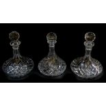 A near pair of cut glass ship's decanters and stoppers, 27cm high, and a further ship's decanter and