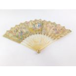 A Continental 19thC ivory and paper stick fan, painted with reserves of chinoiserie figures, against