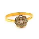 A diamond flower head ring, set with nine diamonds in platinum and yellow metal, stamped 18ct,