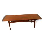 A G Plan teak occasional table, the oblong top raised on turned legs, united by curved stretchers,