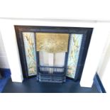 A Victorian Art Nouveau style cast iron fireplace, with a brass hood, and set with two five tile