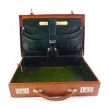 A tooled leather travelling writing or attache case, with fitted interior.