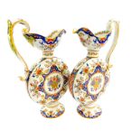 A pair of French faience ewers, of moon flask form, with an s scroll handle, painted with baskets of