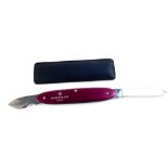 A Patek Philippe watch repairer's folding pocket knife, purple metal cased with two blades, and