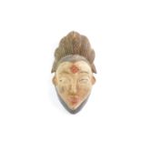 A carved and painted wooden Punu mask, 37cm high.