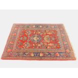 A Turkish red ground prayer rug, the central mihrab framing vases of flowers, birds, trees of