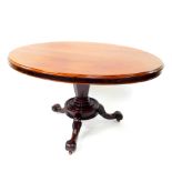 An early Victorian mahogany oval tilt top breakfast table, raised on an hexagonal column and