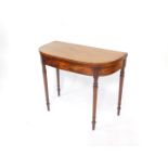 A George IV mahogany demilune fold over card table, with ebony lined inlay, green baize interior,