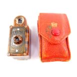 A Coronet midget camera, in a brown marbled Bakelite casing, with outer red leather wallet, 6cm