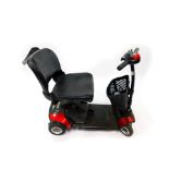 A Go-Go red mobility scooter, with battery and key.